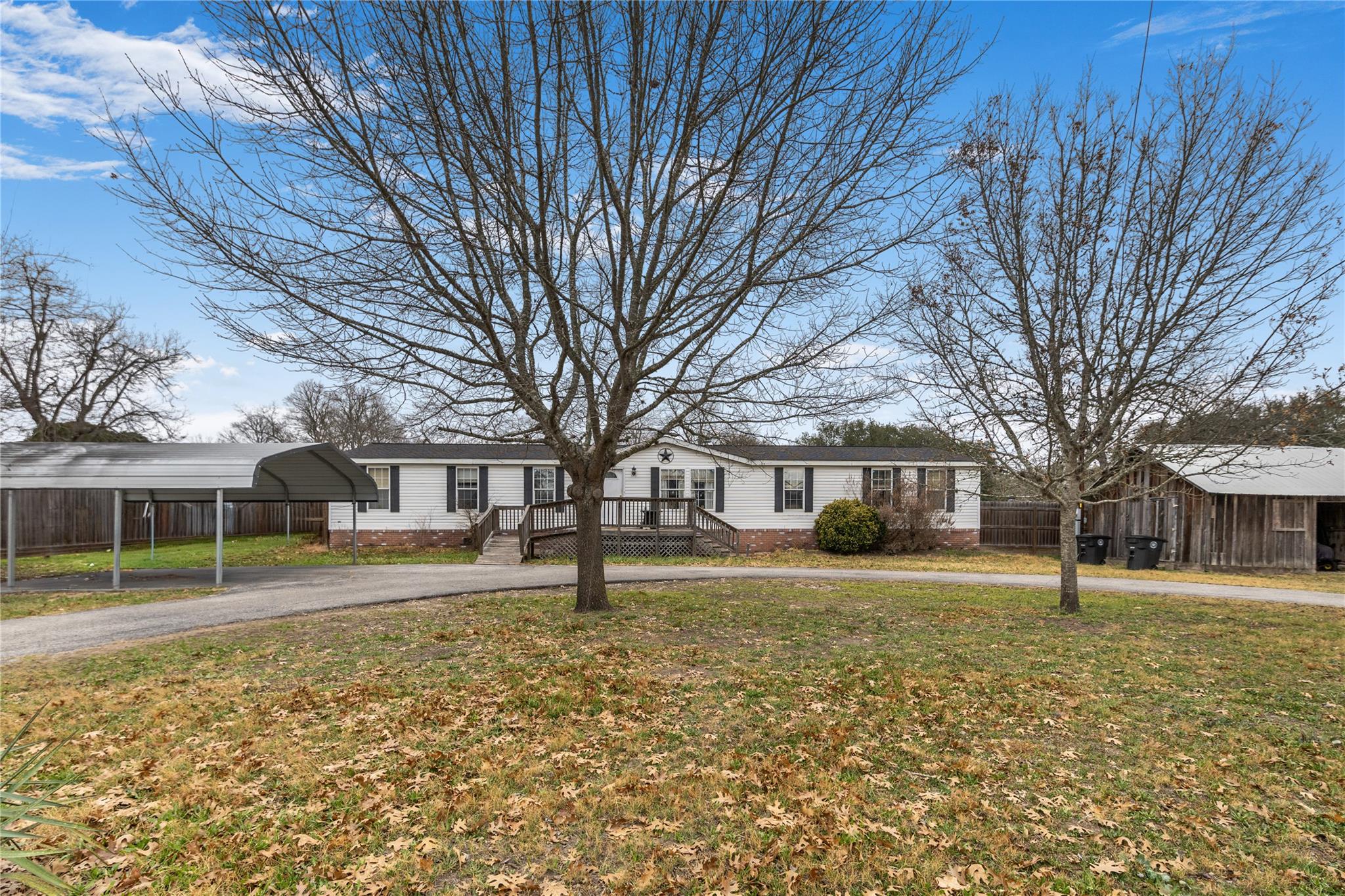 Ranch-style home with a carport and curved drivew