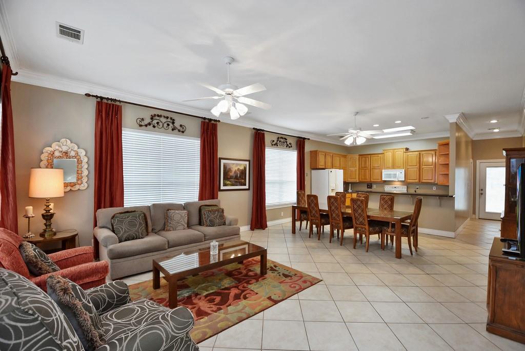 Living area with ornamental molding, light tile p