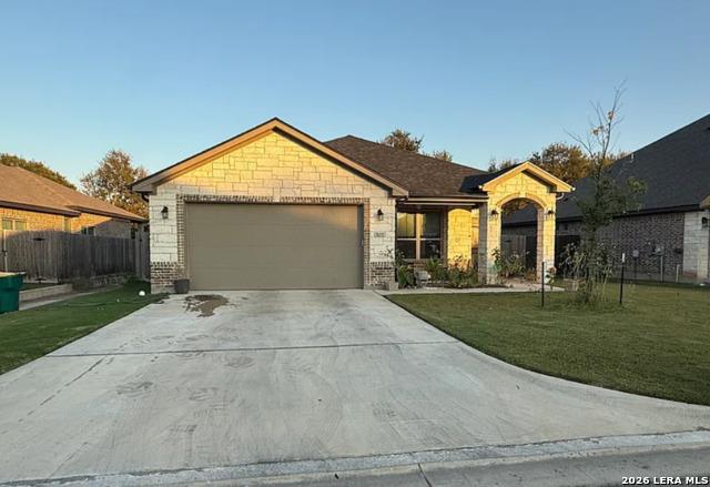 Single story home featuring driveway, a garage, b