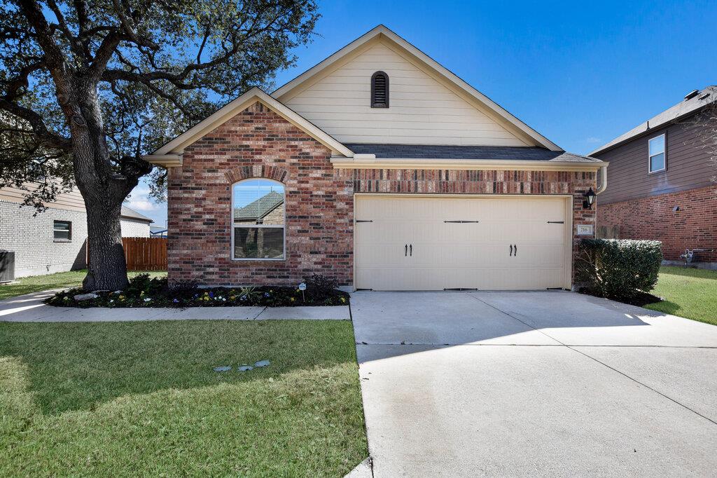 Single story home with brick siding, driveway, a 