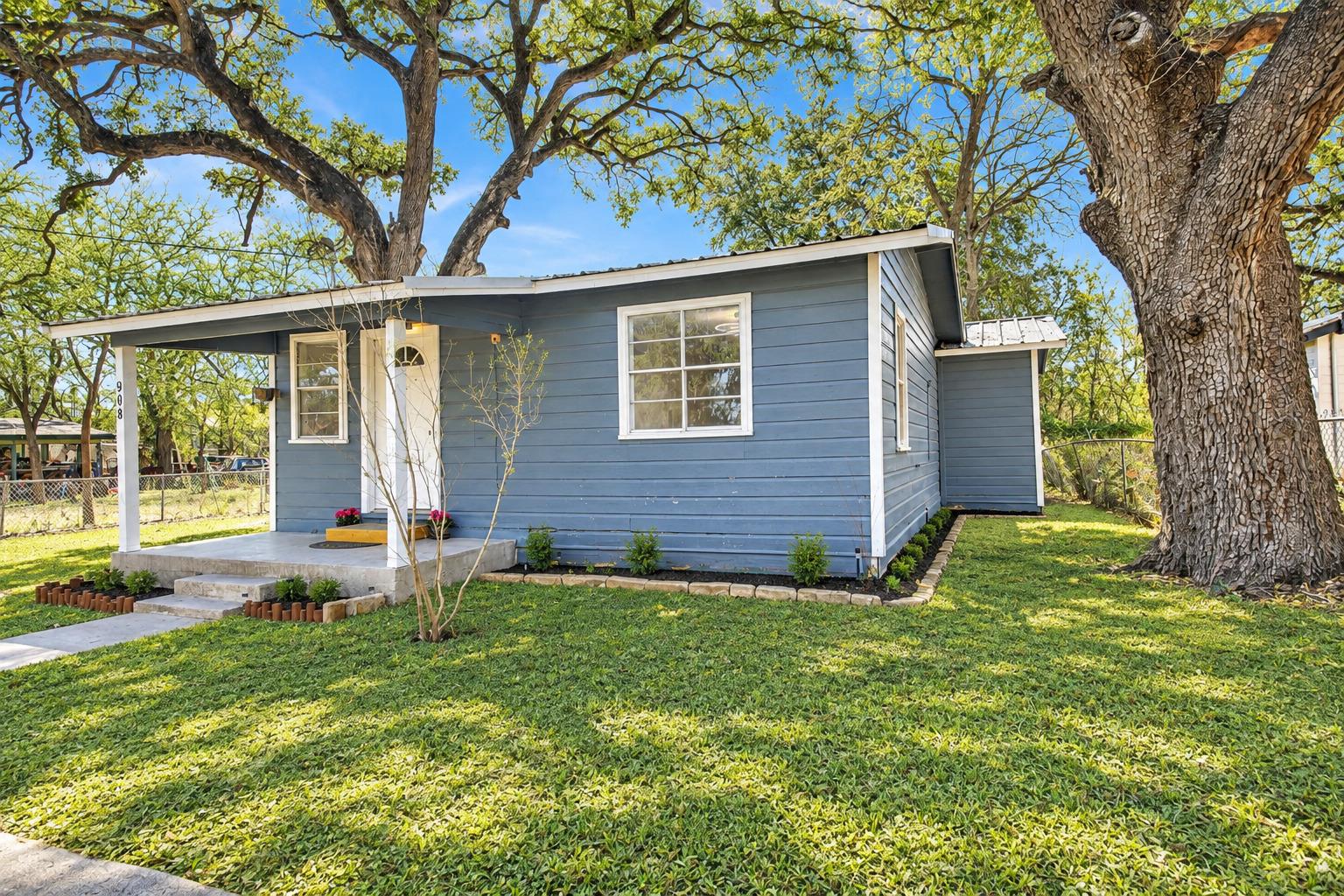 Mature shade trees frame this classic single-stor