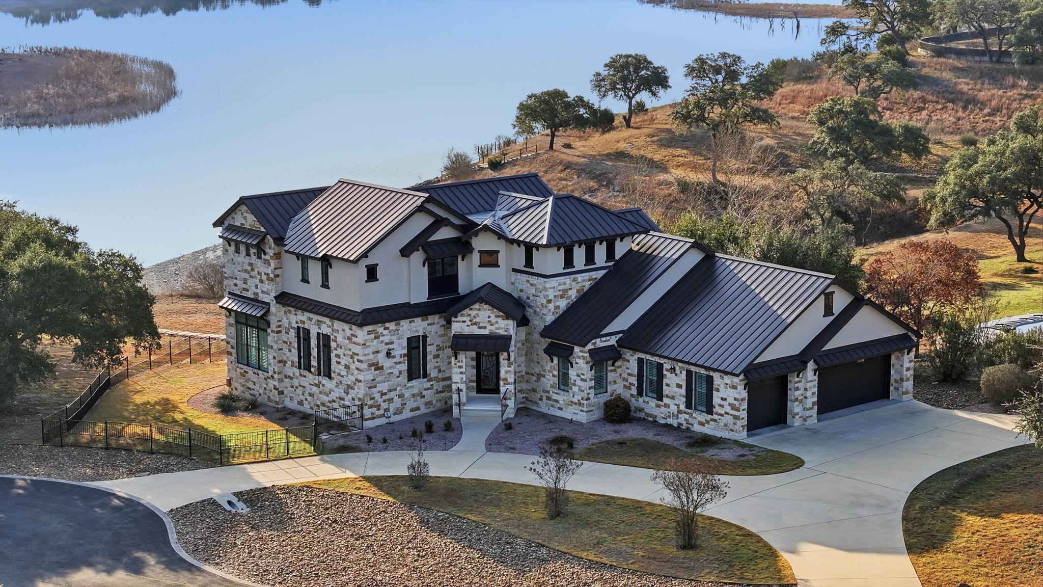 View of front facade featuring stone siding, curv