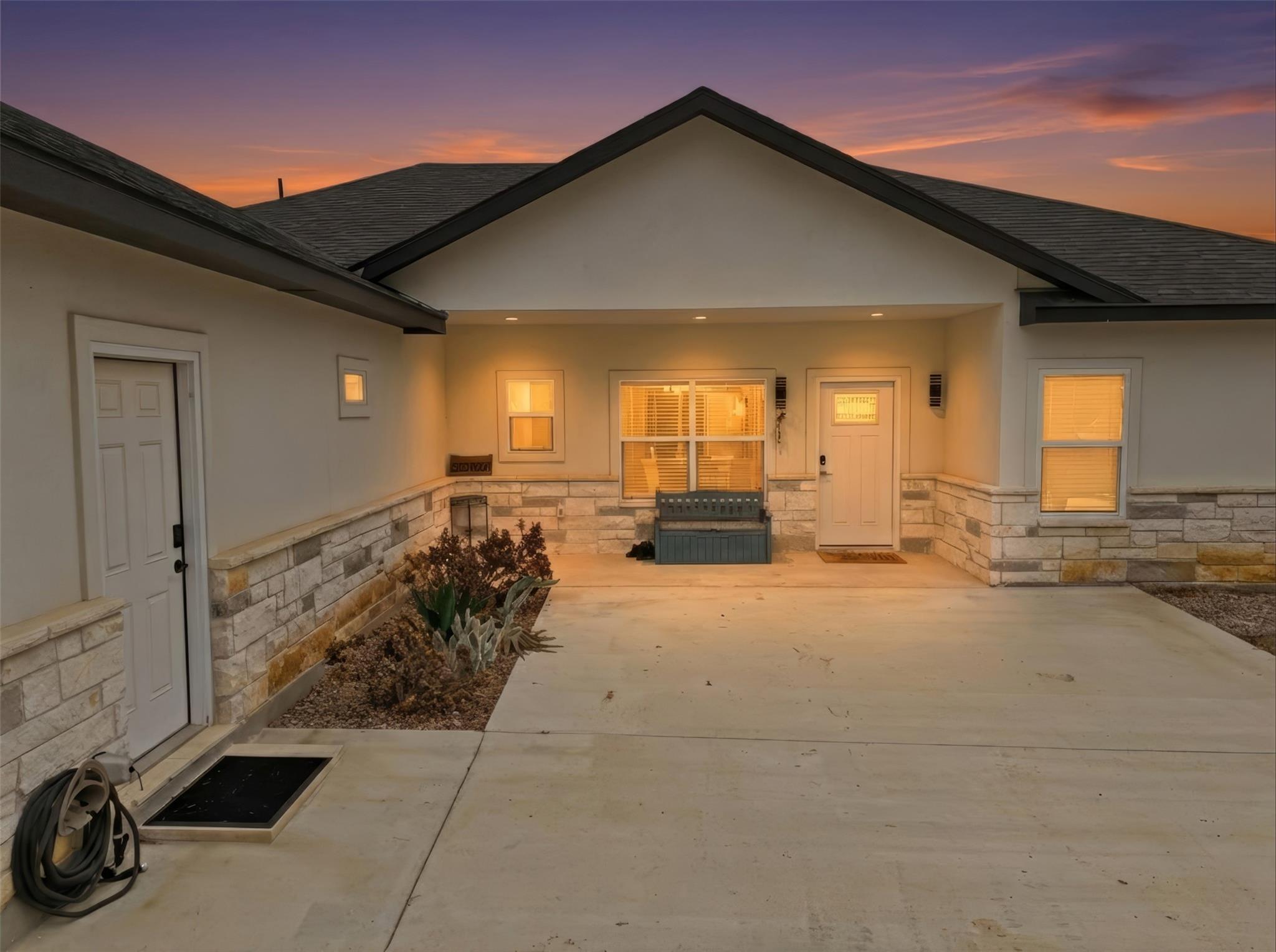Property entrance featuring stone siding, stucco 