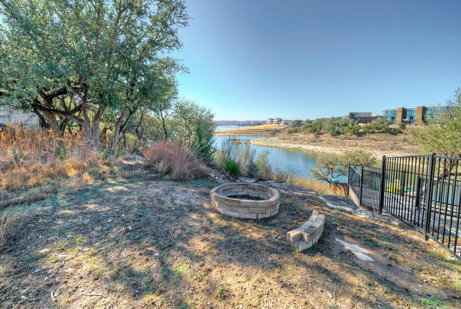 View of yard with an outdoor fire pit and a water