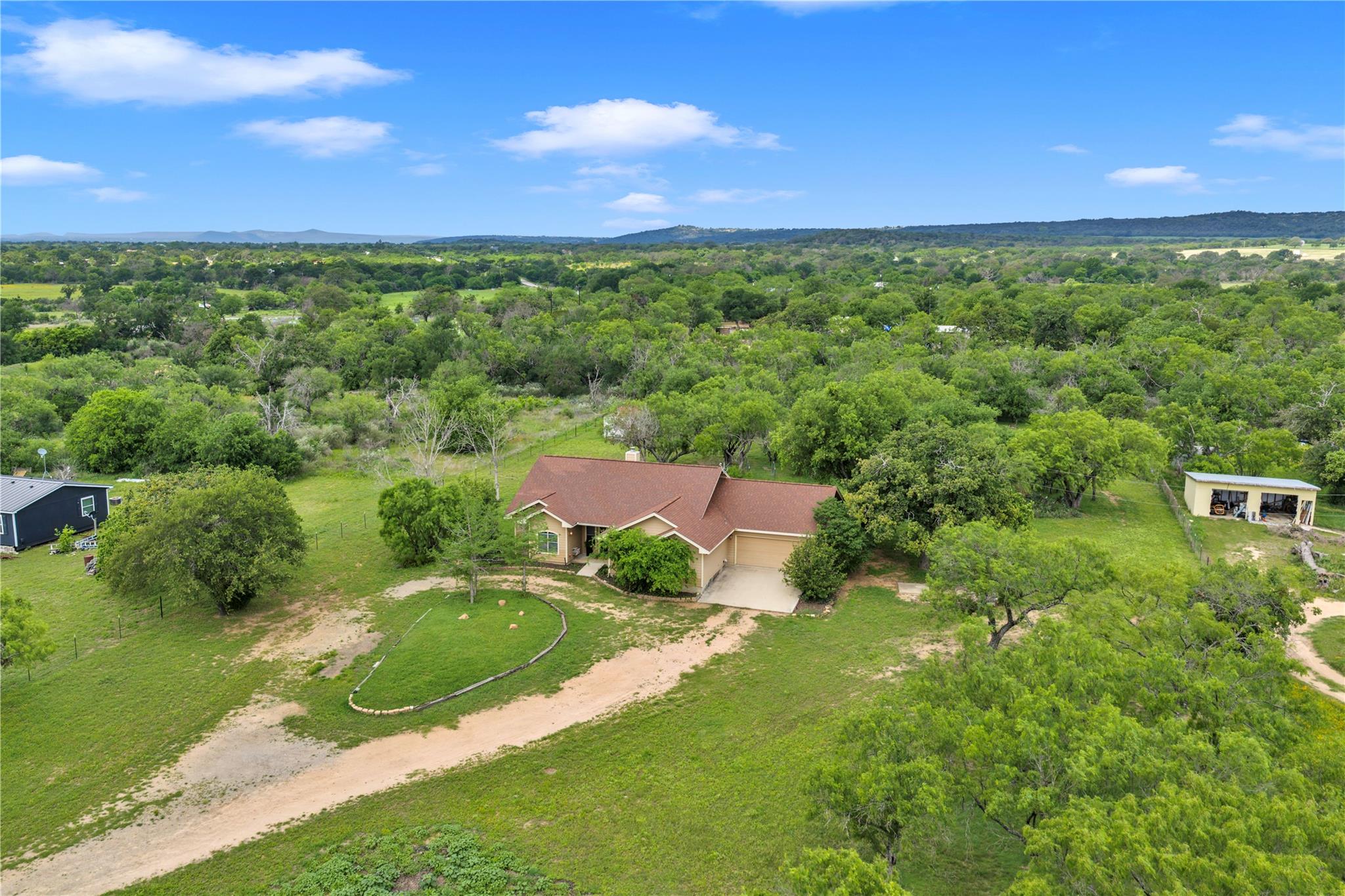 Rolling green pastures and mature trees surround 