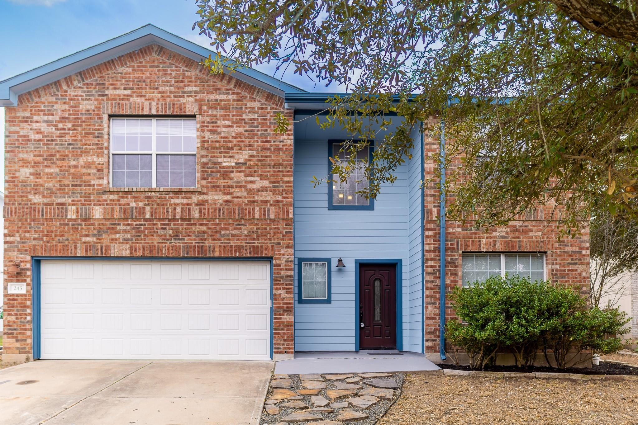 View of front of home featuring driveway, an atta
