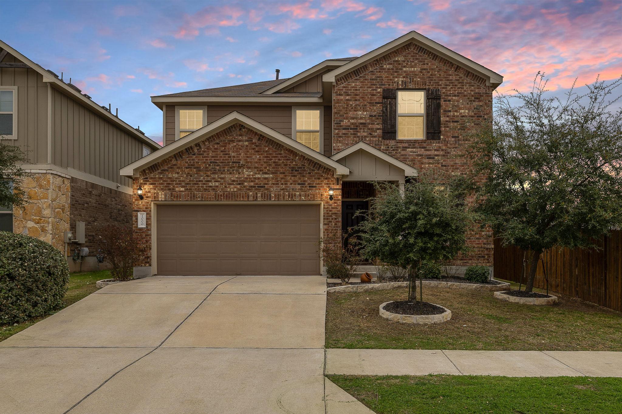 Traditional home with brick siding, an attached g