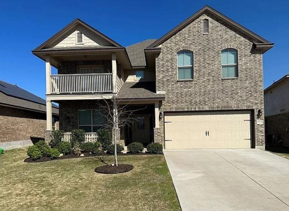 View of front of property with a balcony, brick s
