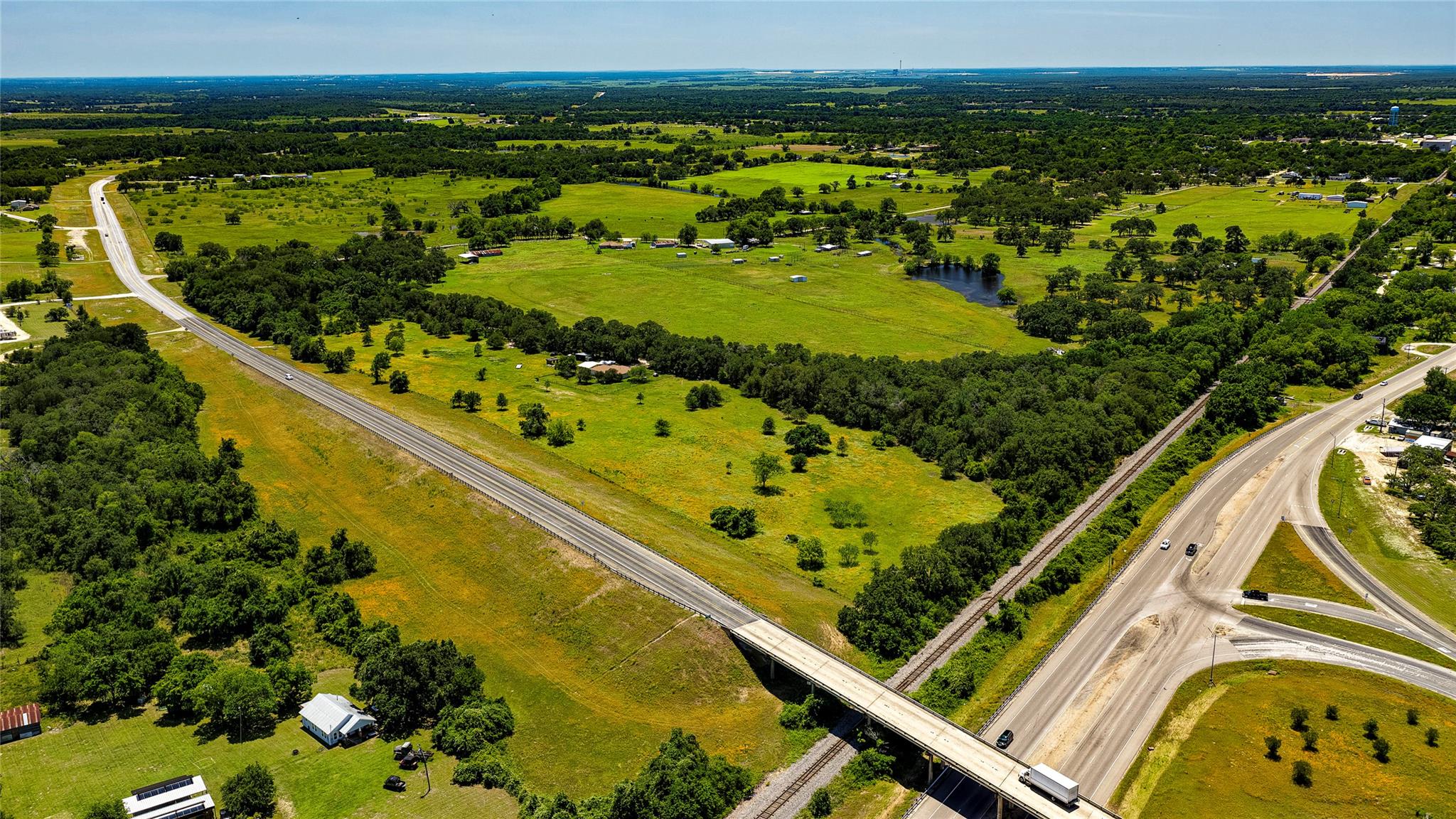 Expansive acreage featuring a pond, mature trees,