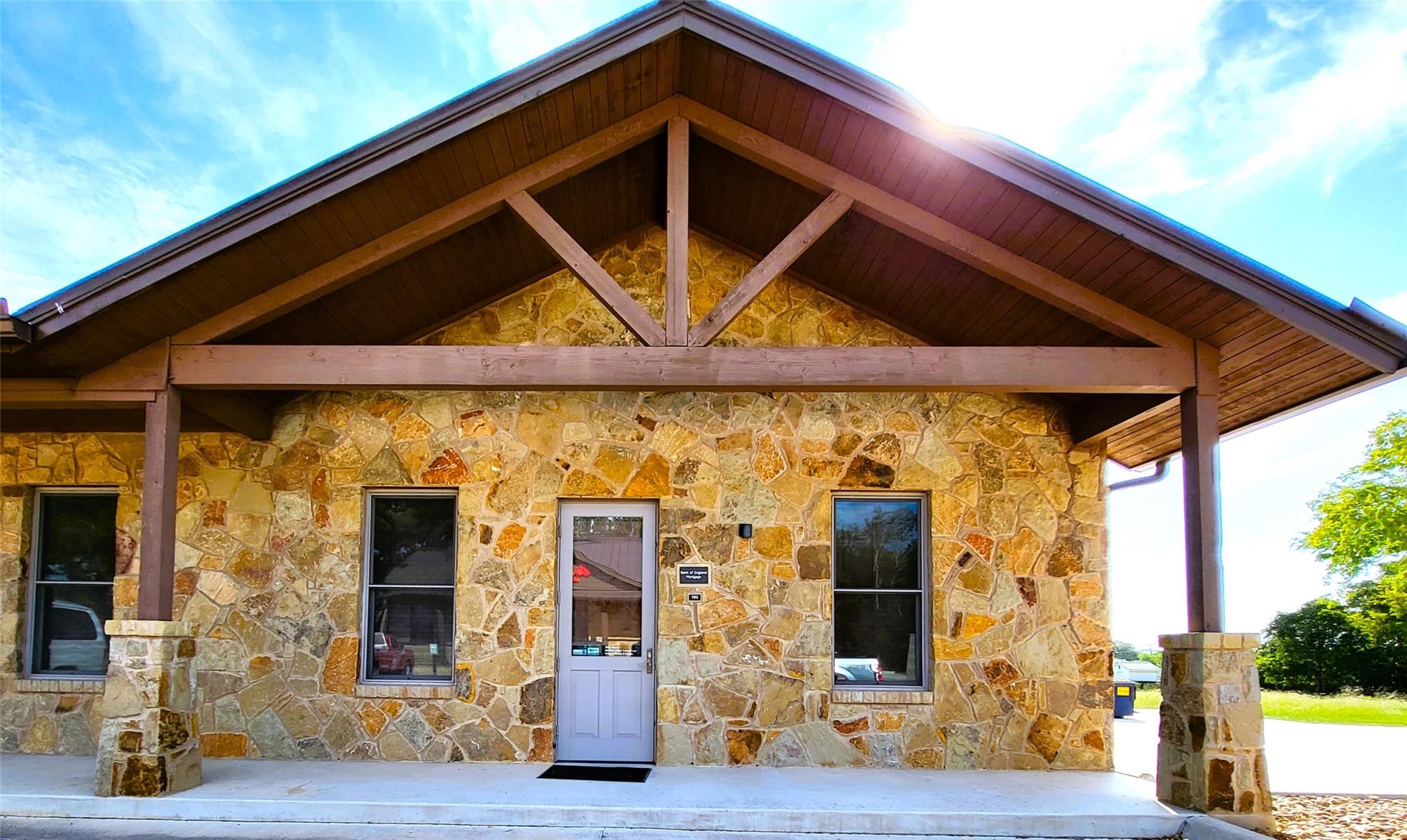 Property entrance with a porch and stone siding