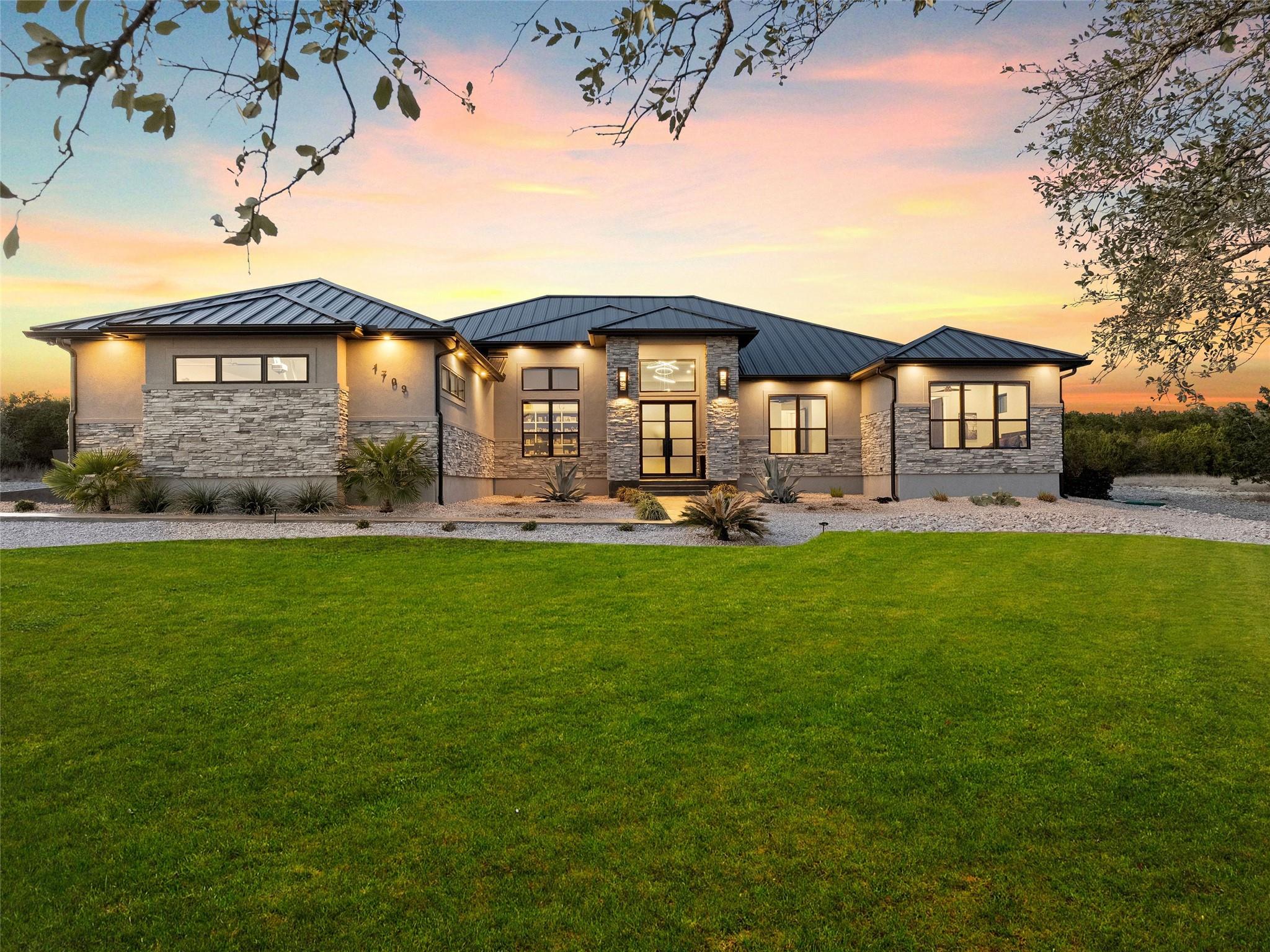Rear view of house featuring stone siding, a stan