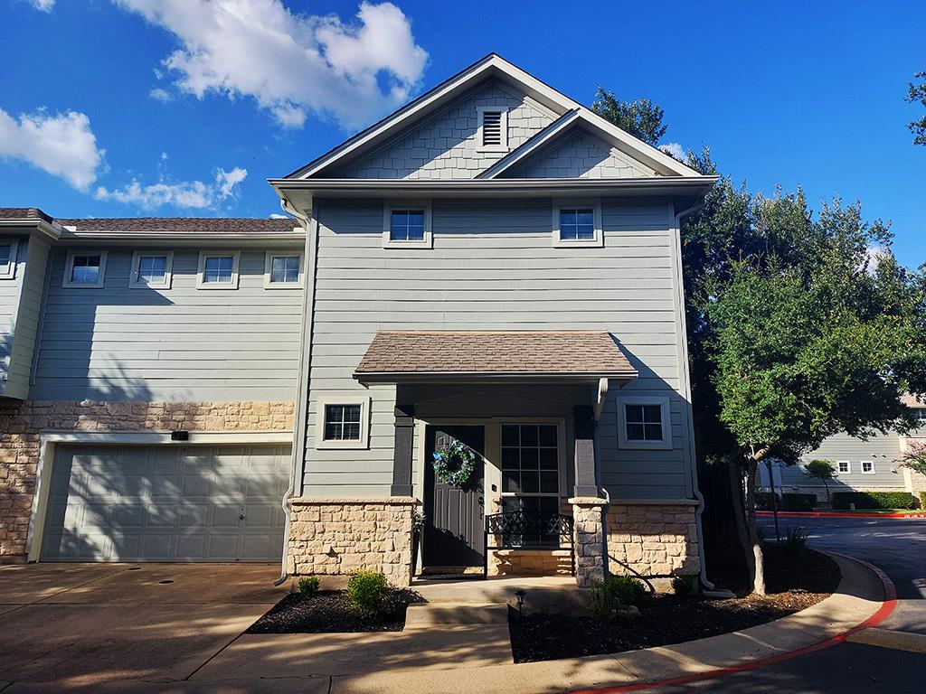 A welcoming stone and siding facade offers classi