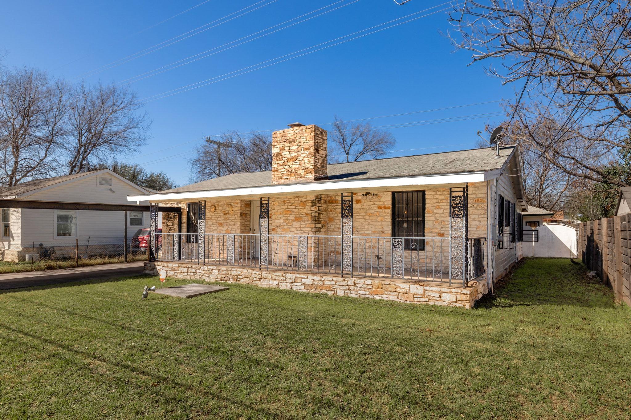 Rear view of property with a chimney, stone sidin