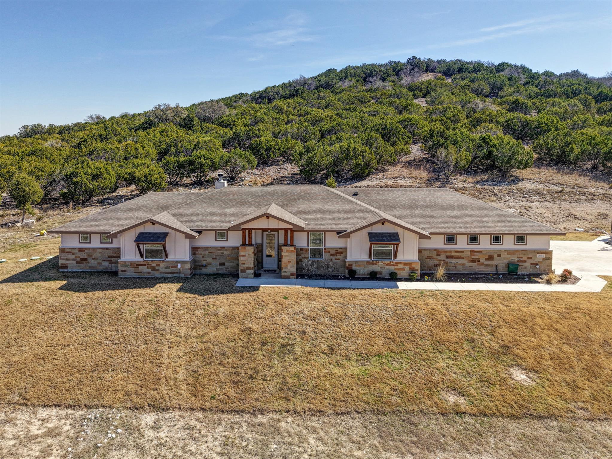 View of front of home featuring stone siding, a f