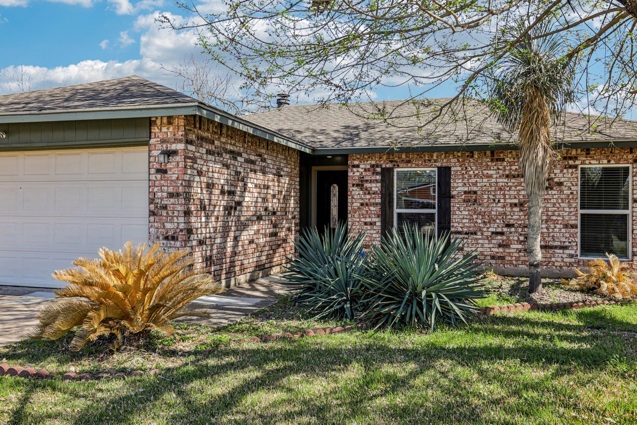 Ranch-style house featuring a garage, brick sidin