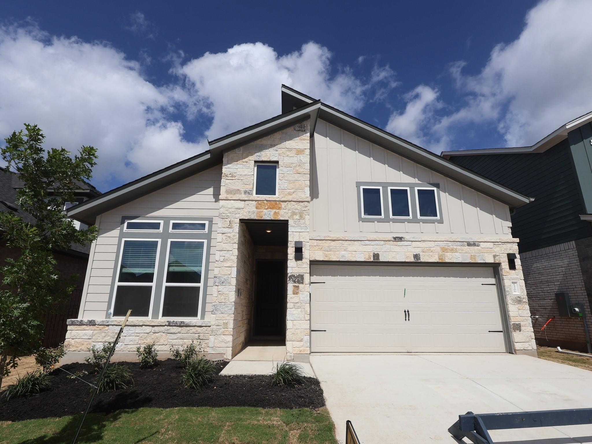 Modern facade with a blend of siding and stone ac