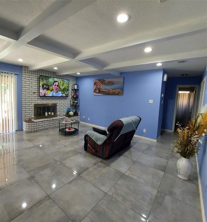 Living room featuring a textured ceiling, a firep