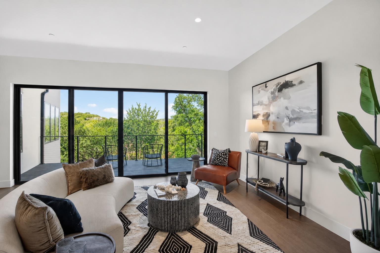 Floor-to-ceiling glass doors provide verdant hill
