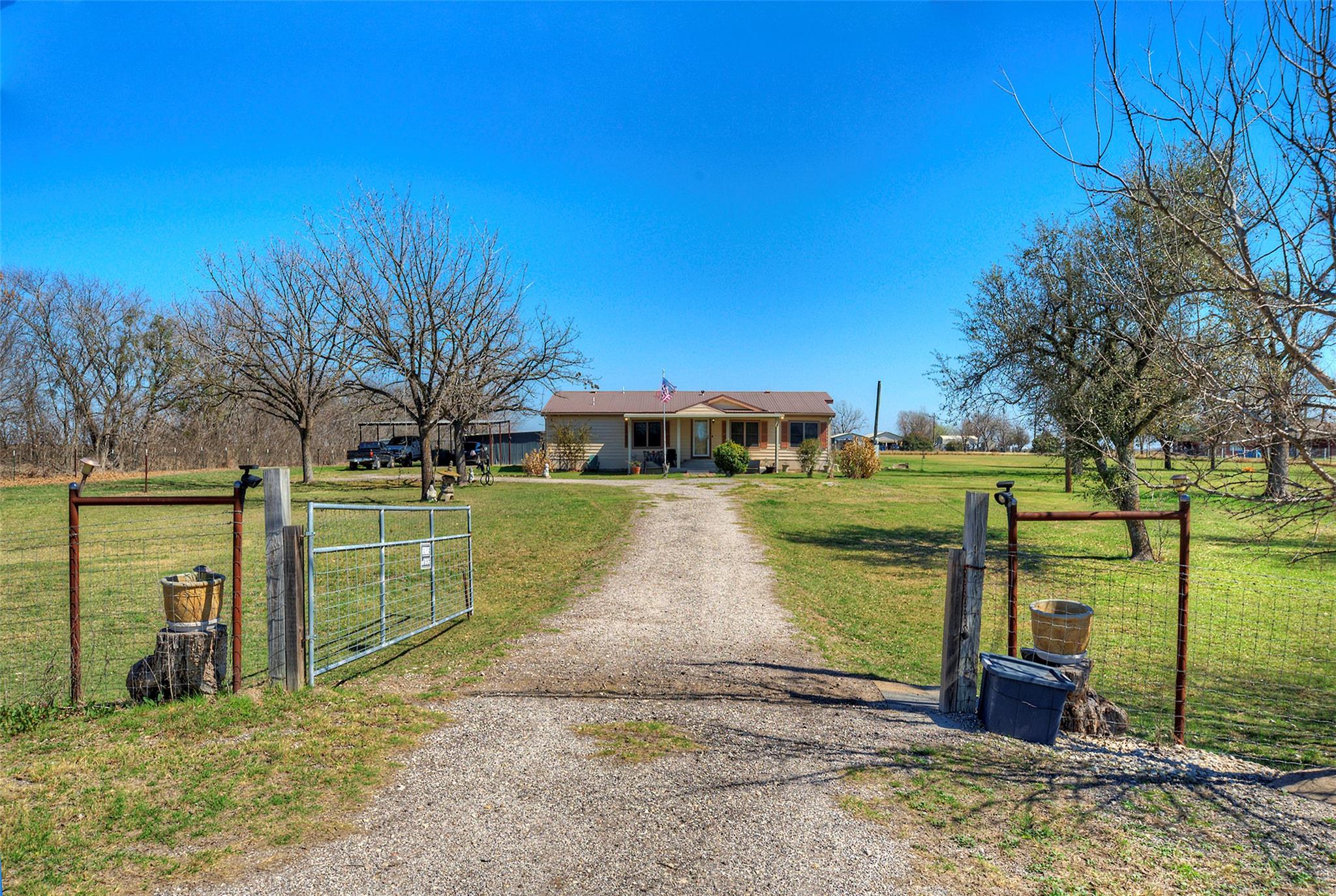 View of front of property featuring a gate, a por
