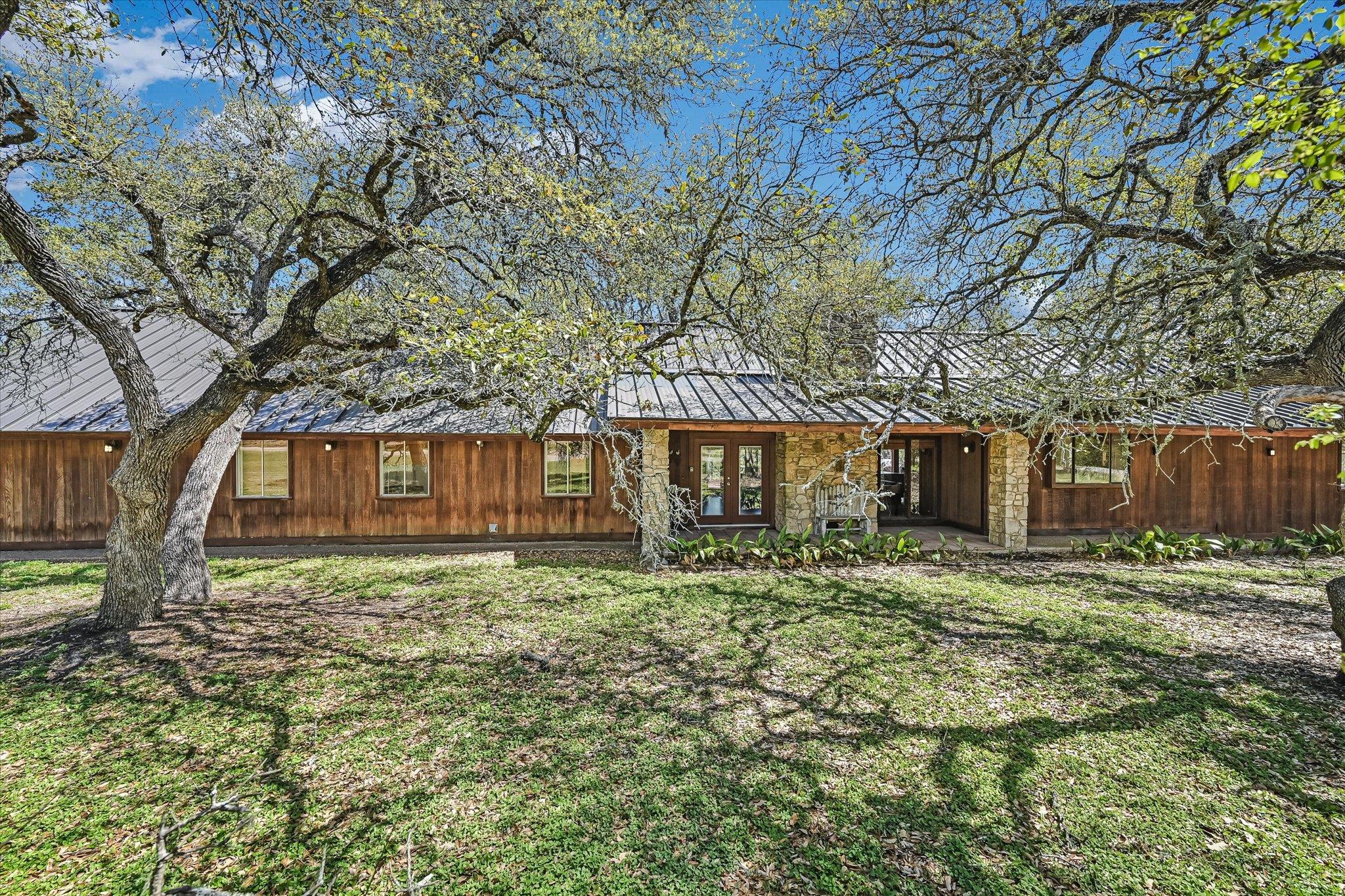 Rear view of house with a yard, french doors, and
