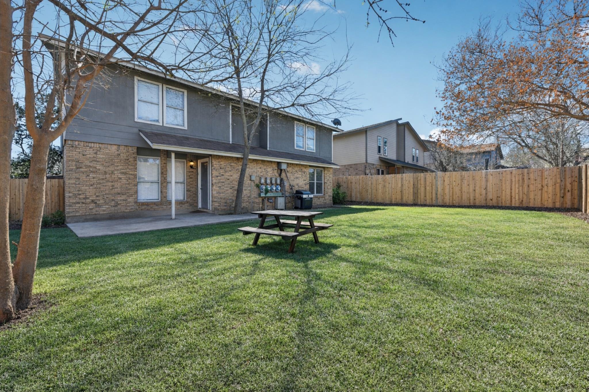 Rear view of house featuring a fenced backyard, a