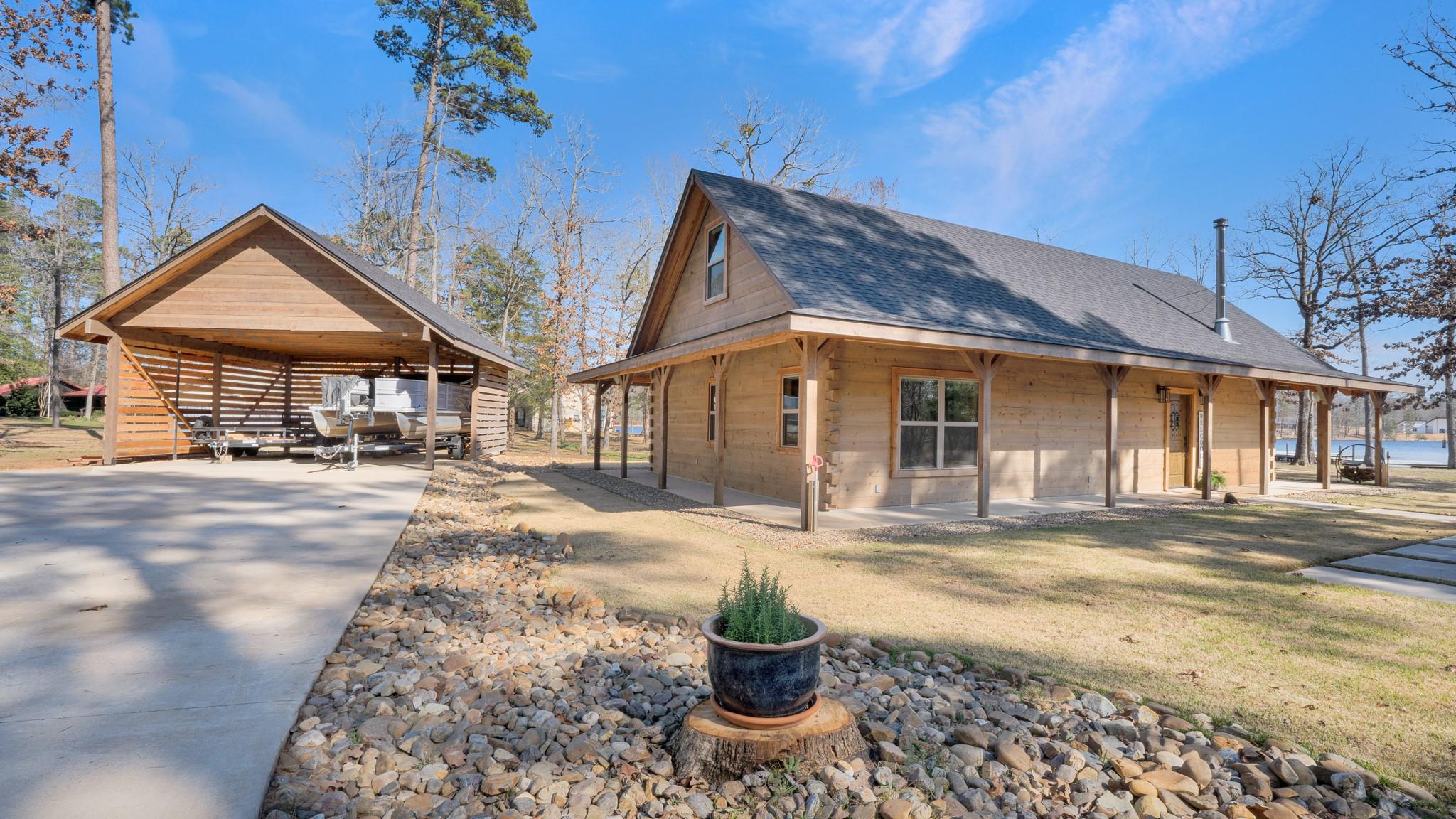 View of side of home featuring driveway, a carpor