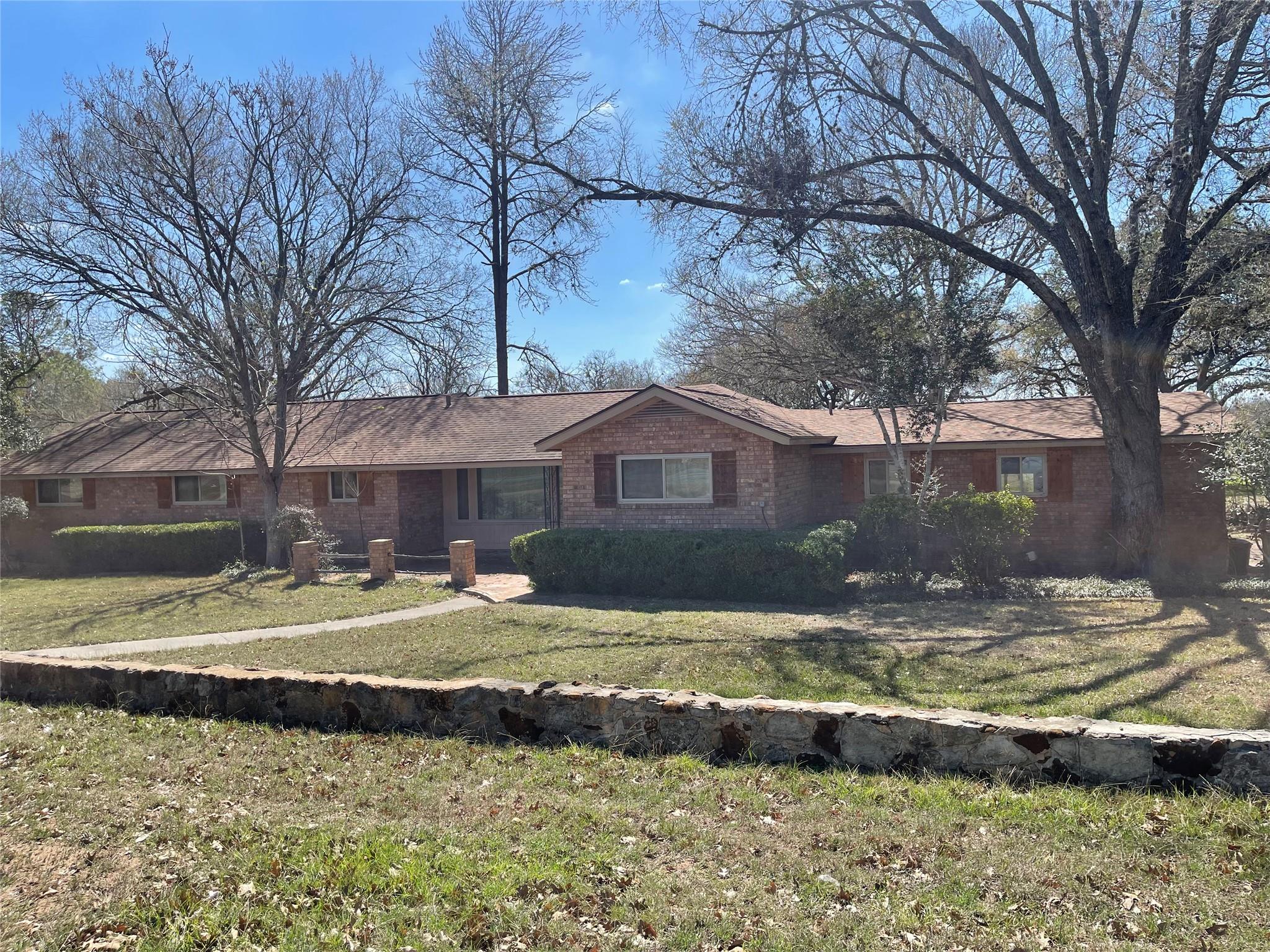 Ranch-style house featuring a front lawn and bric