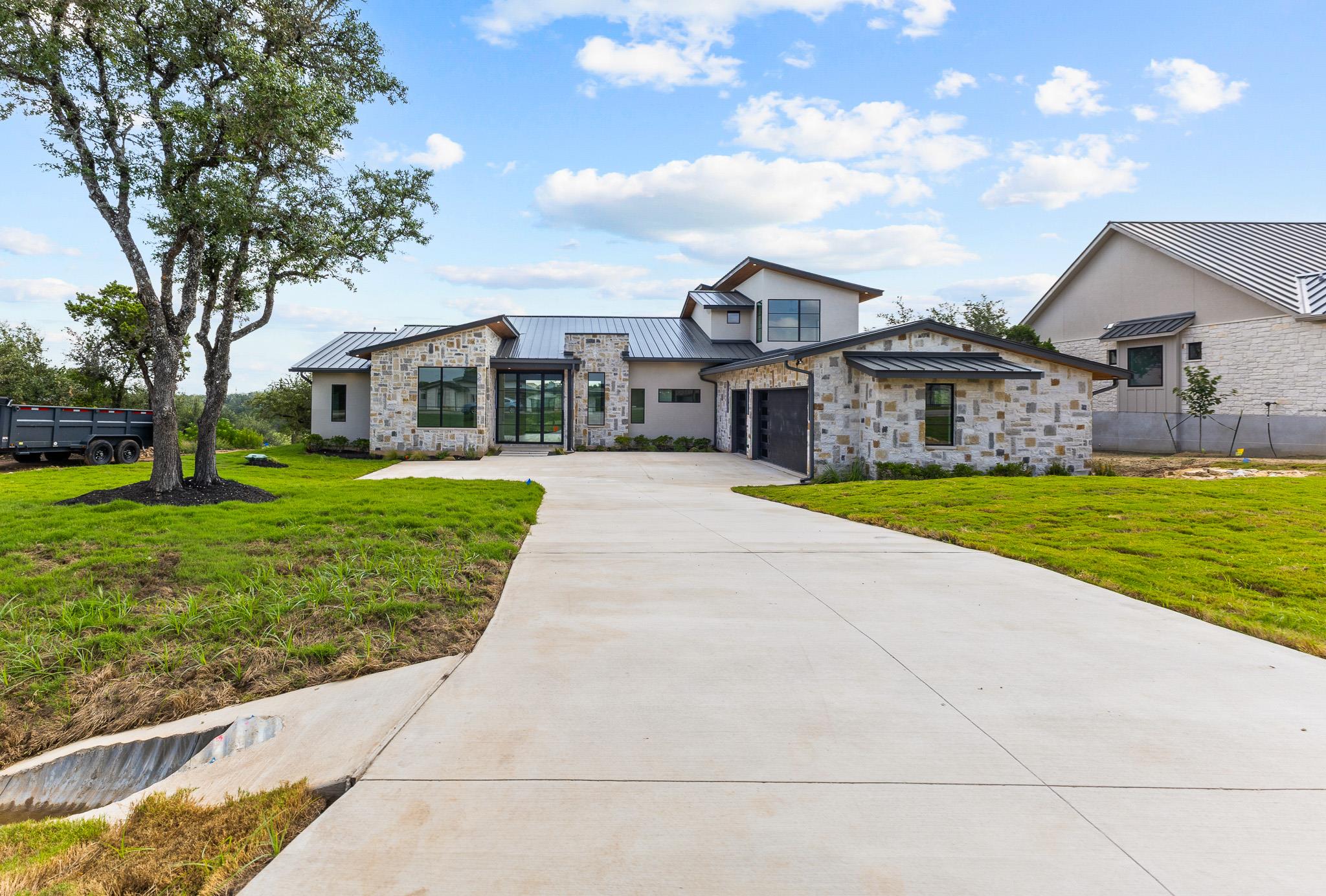 A long, concrete driveway leads to this contempor