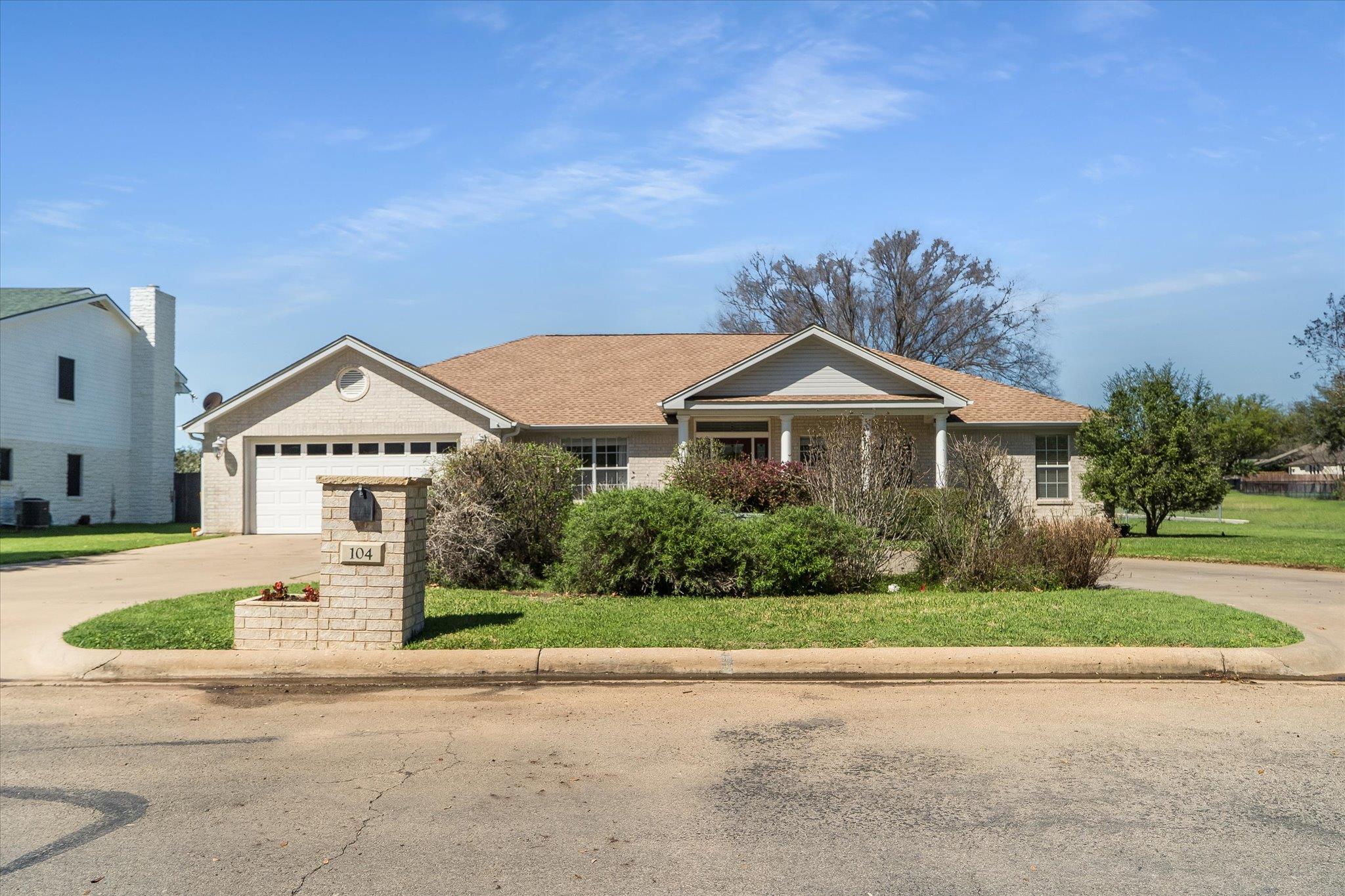 Ranch-style home with a front yard, driveway, a g