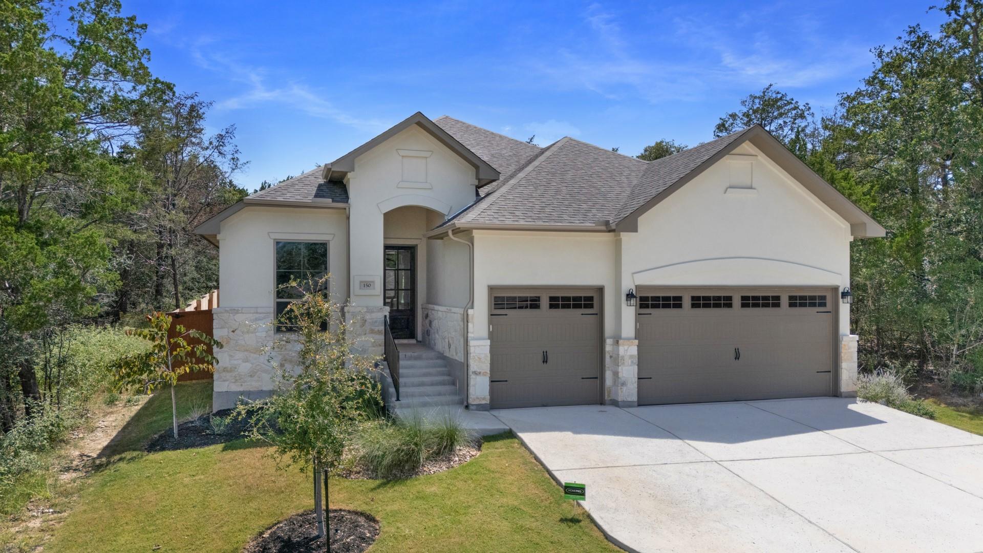 A graceful home with stucco and stone accents wel