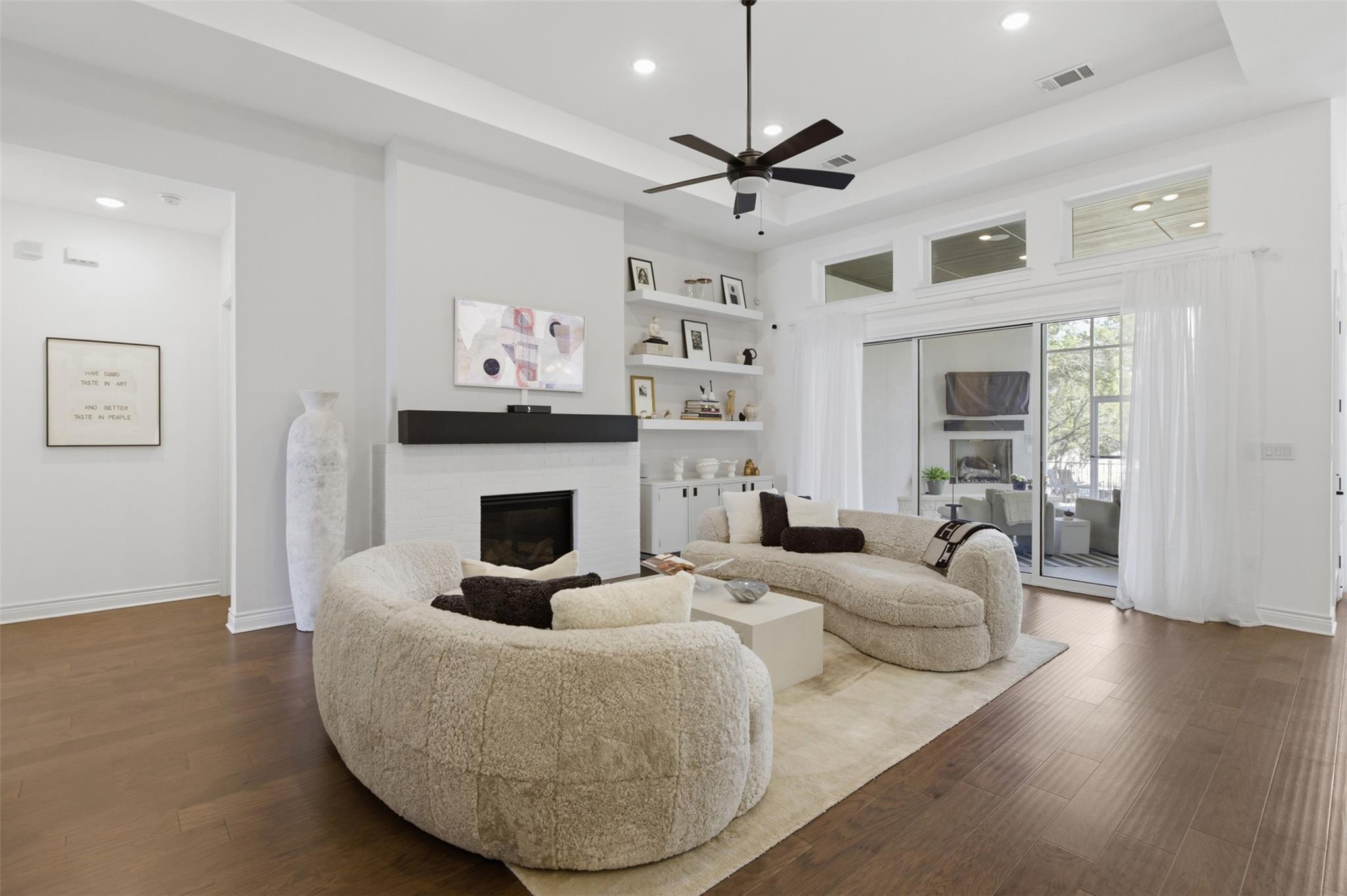 Living room featuring a tray ceiling, dark wood f