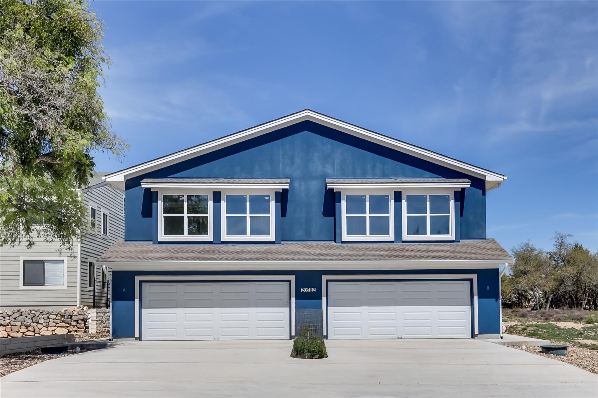 View of front of house featuring driveway, roof w