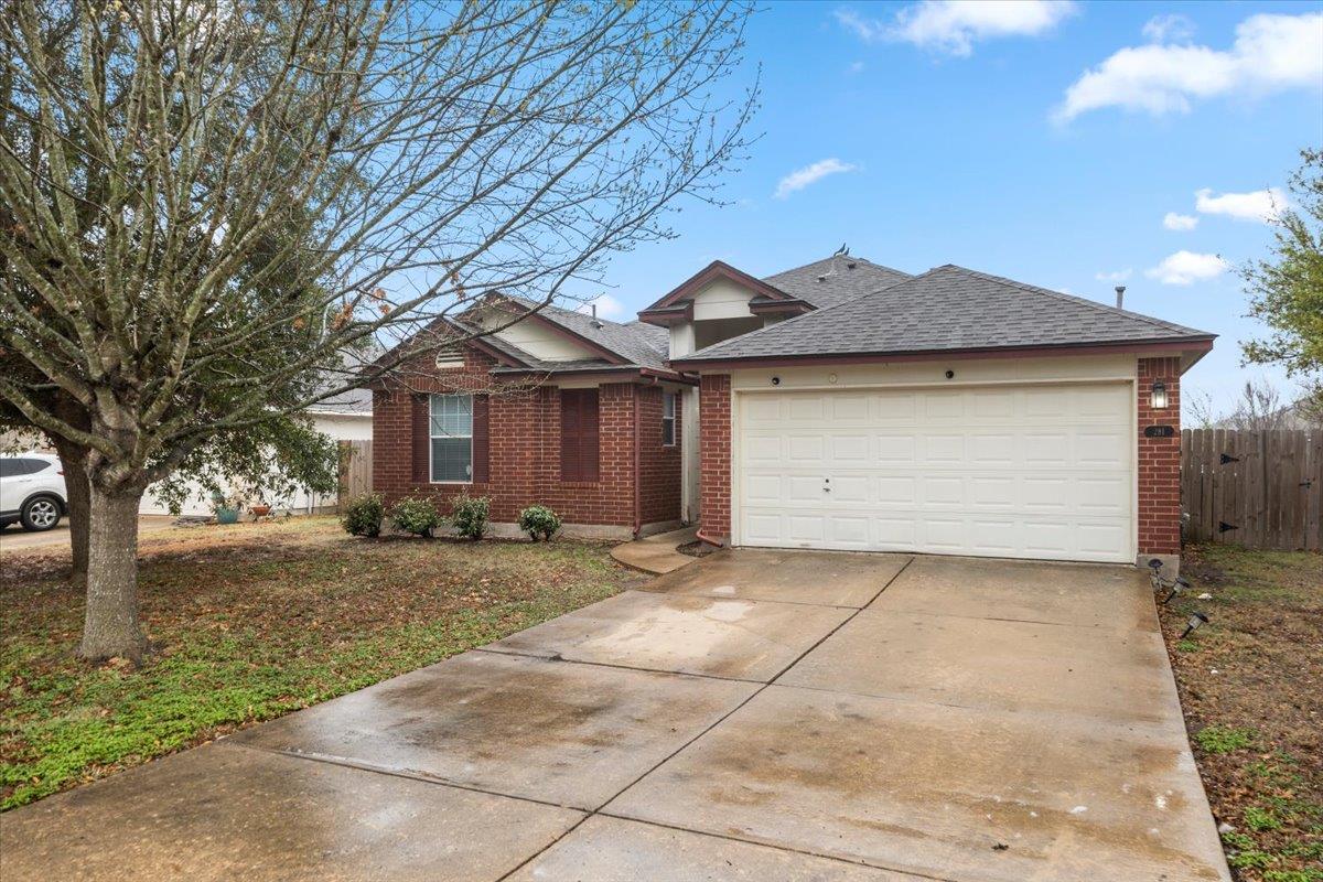 Ranch-style home with brick siding, concrete driv