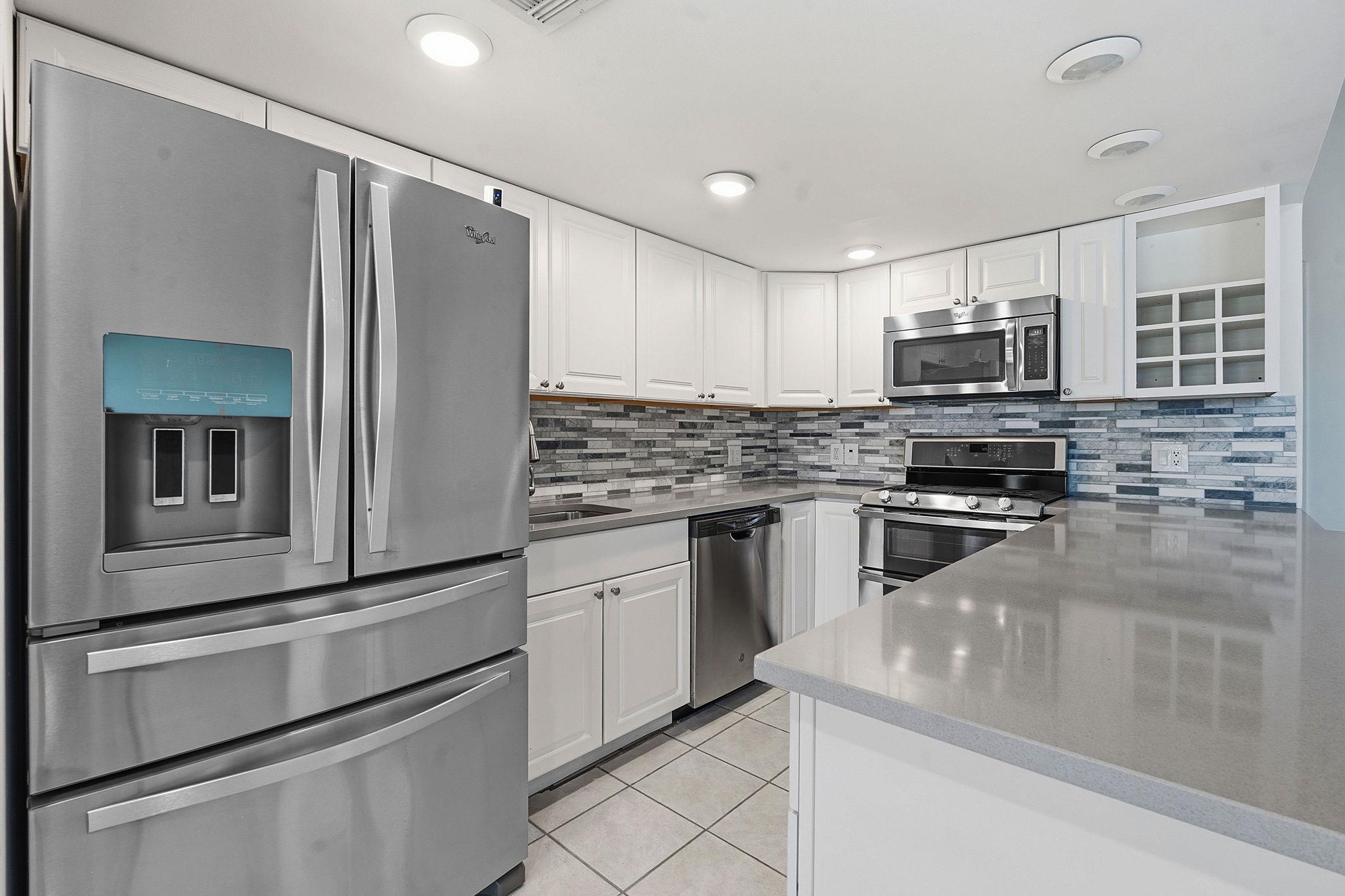 Kitchen with stainless steel appliances, white ca