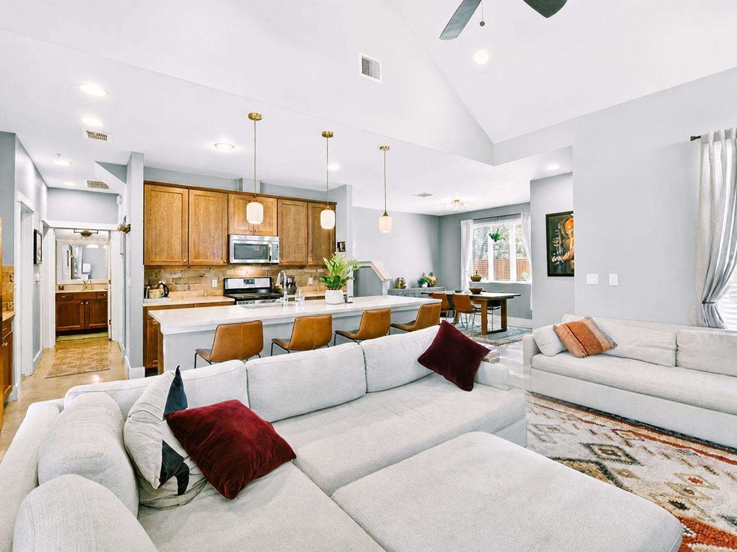 Open-concept living space featuring a vaulted cei