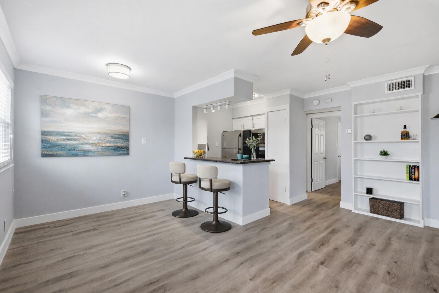 Kitchen with a kitchen bar, crown molding, white 