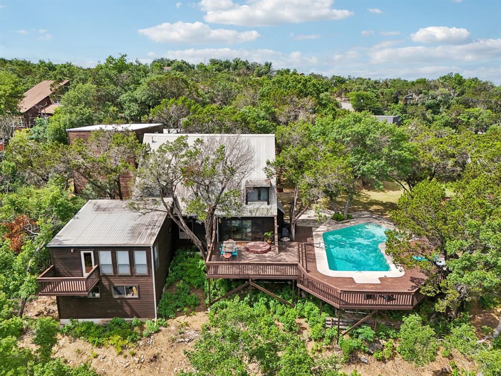 View of subject property with a pool and a tree f