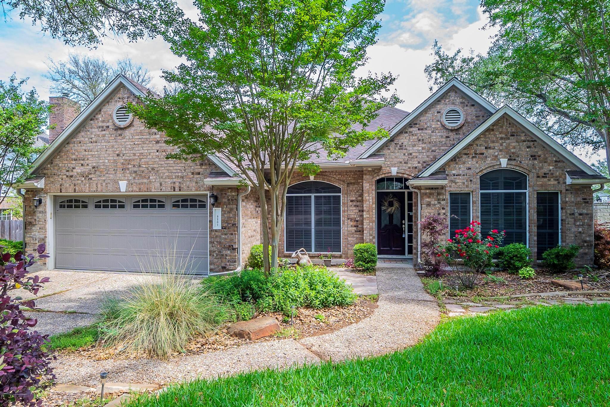 View of front of home featuring brick siding, dri