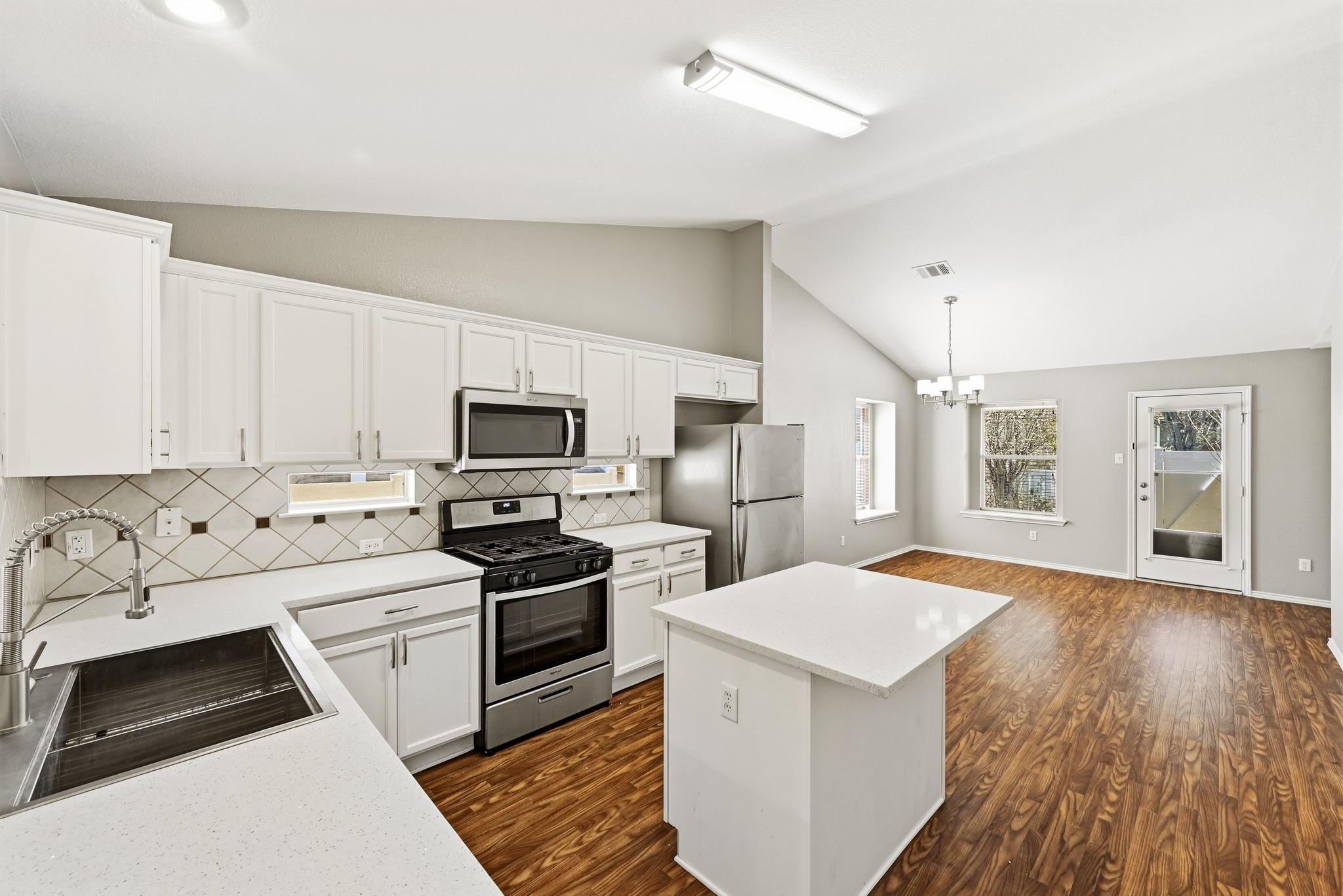 Kitchen with stainless steel appliances, white ca