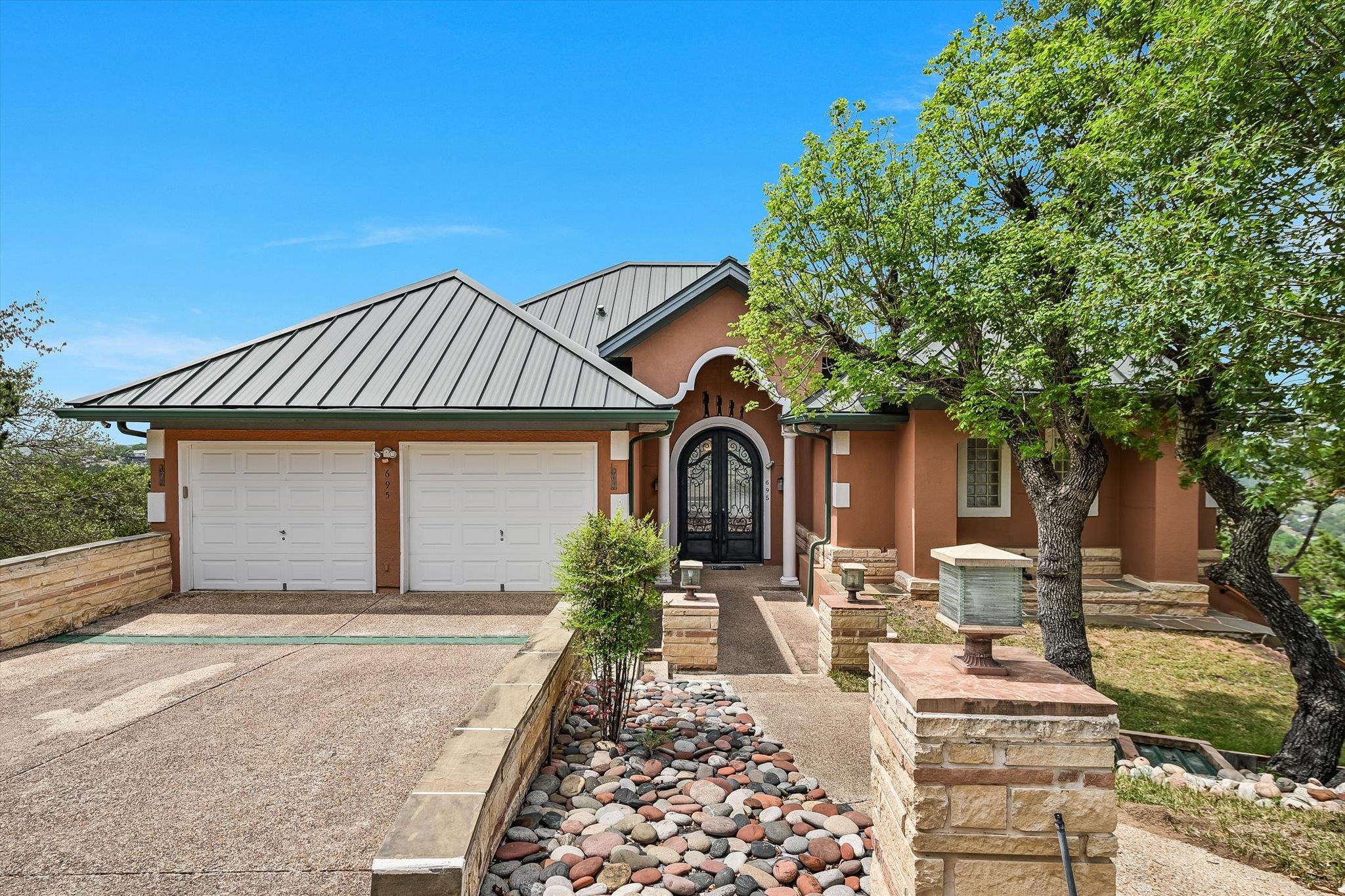 Stucco exterior residence featuring a metal roof 