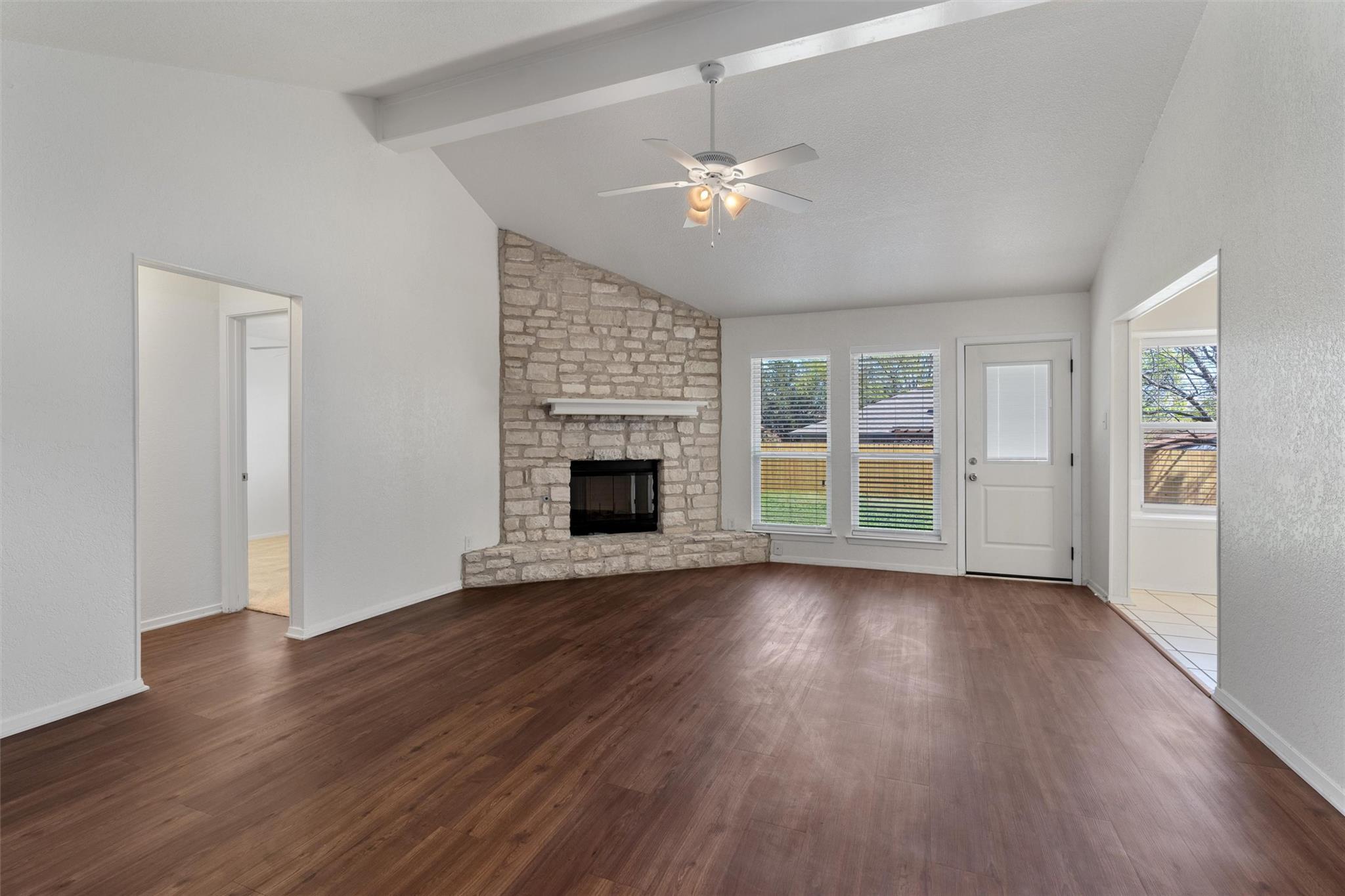 Unfurnished living room featuring a stone firepla