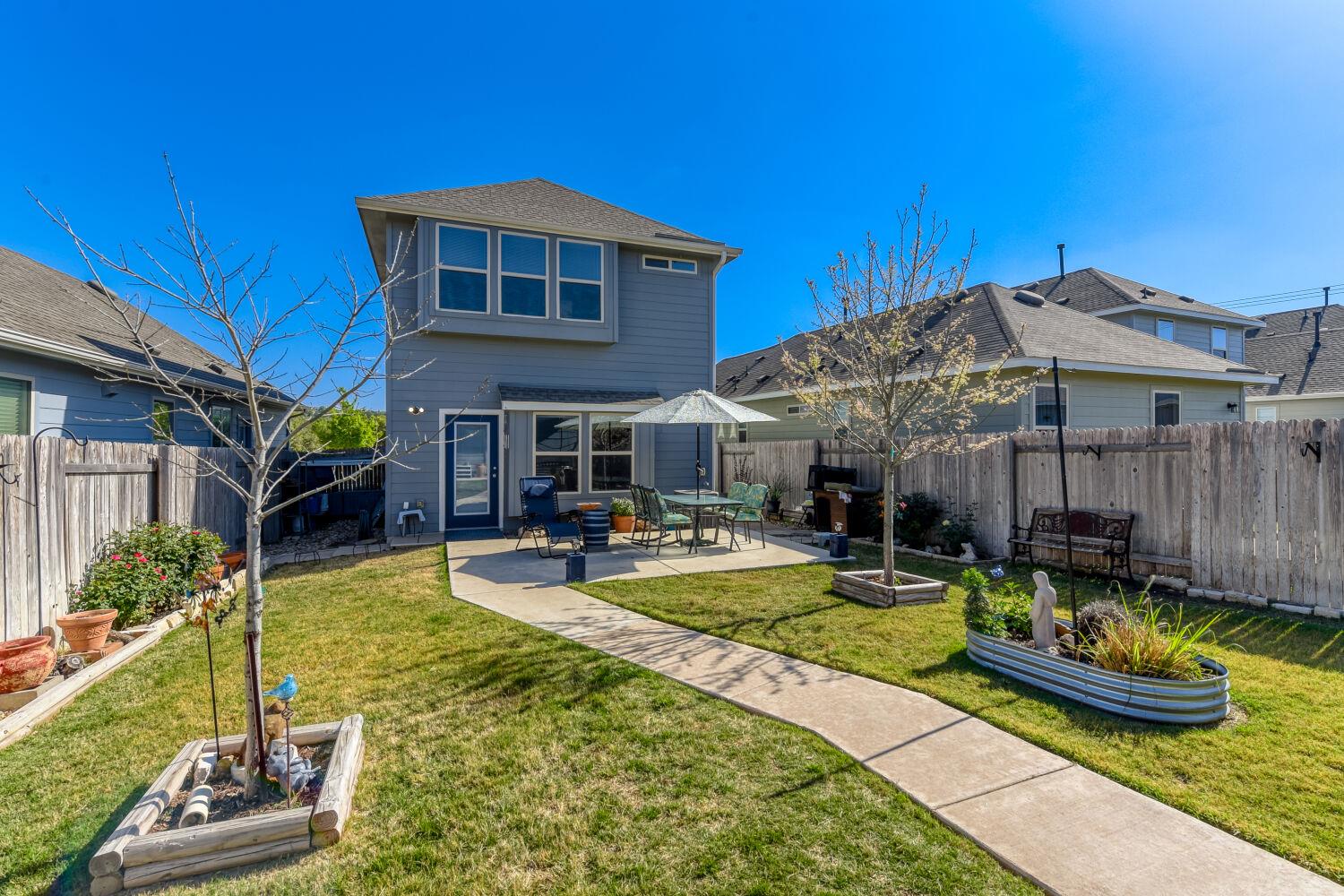 Back of property with a vegetable garden, a patio