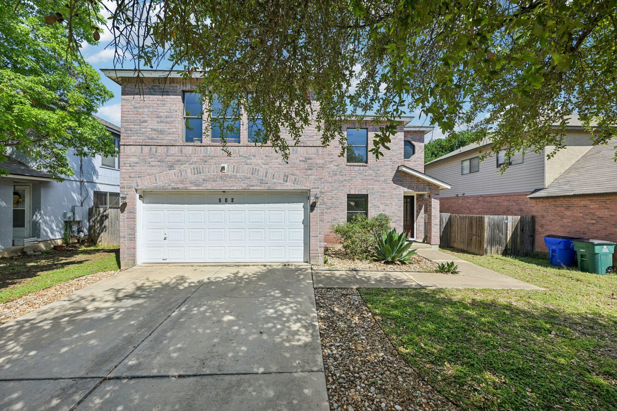 Traditional home featuring brick siding, driveway