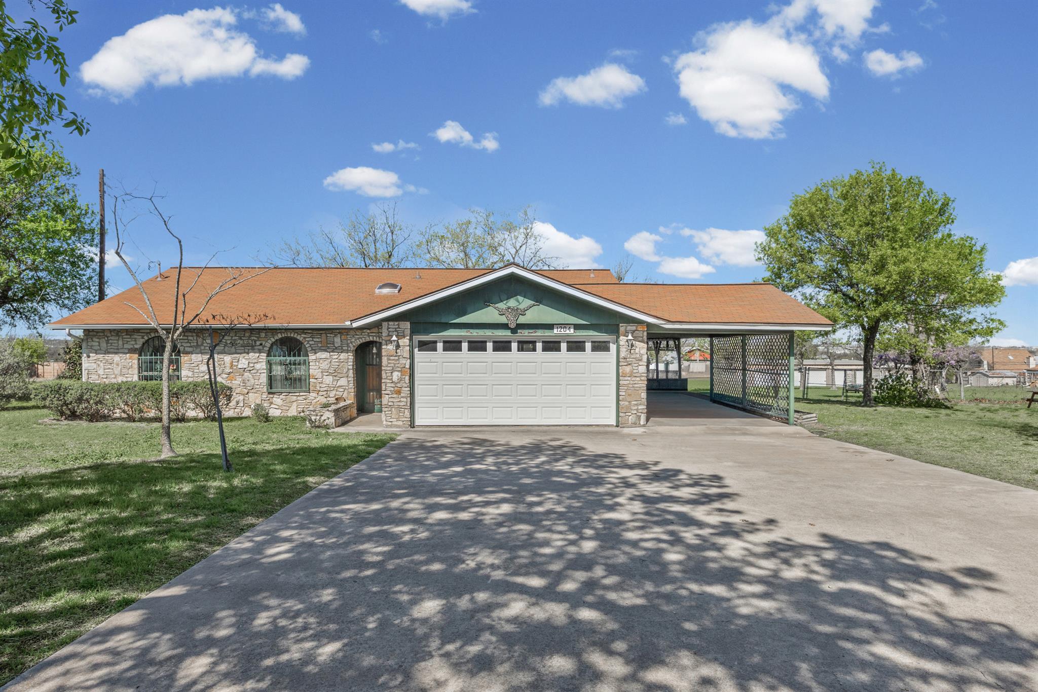 Single story home with a front yard, stone siding
