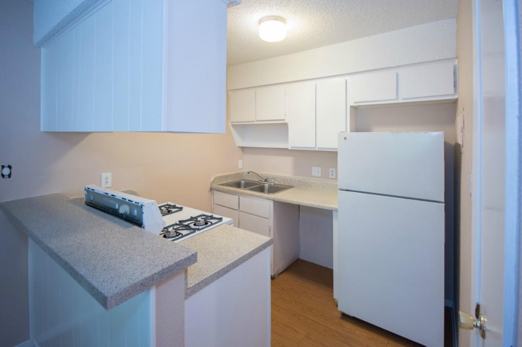 Kitchen with white appliances, white cabinetry, a