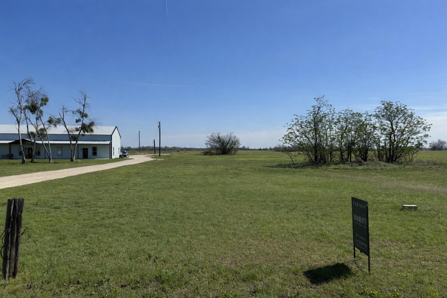 View of green lawn featuring driveway and a rural