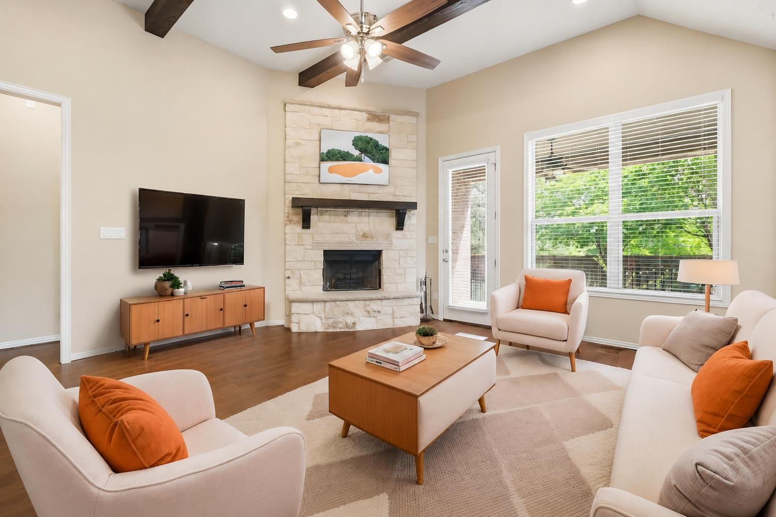Rich wood floors and a stone fireplace anchor thi