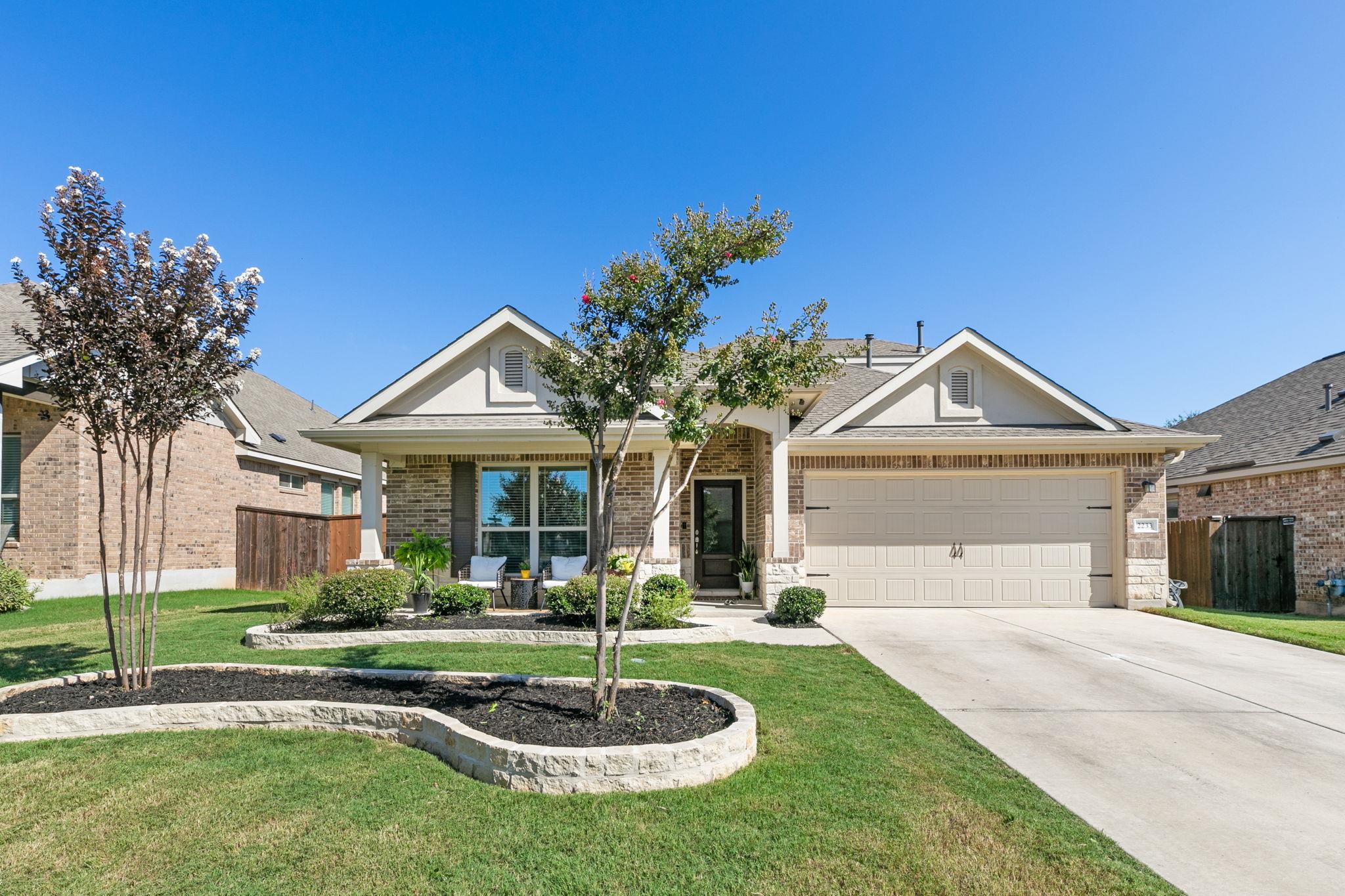 View of front of home with driveway, an attached 