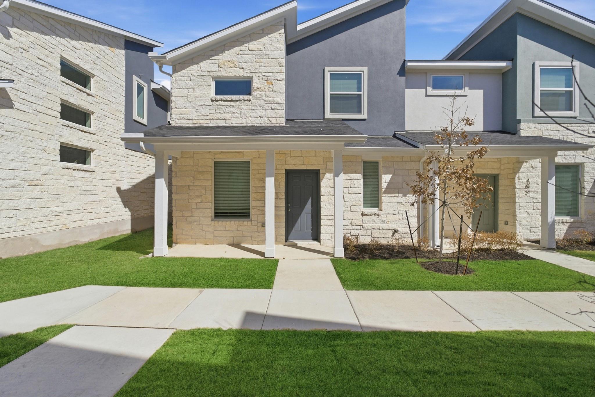 View of front of home featuring stone siding, cov