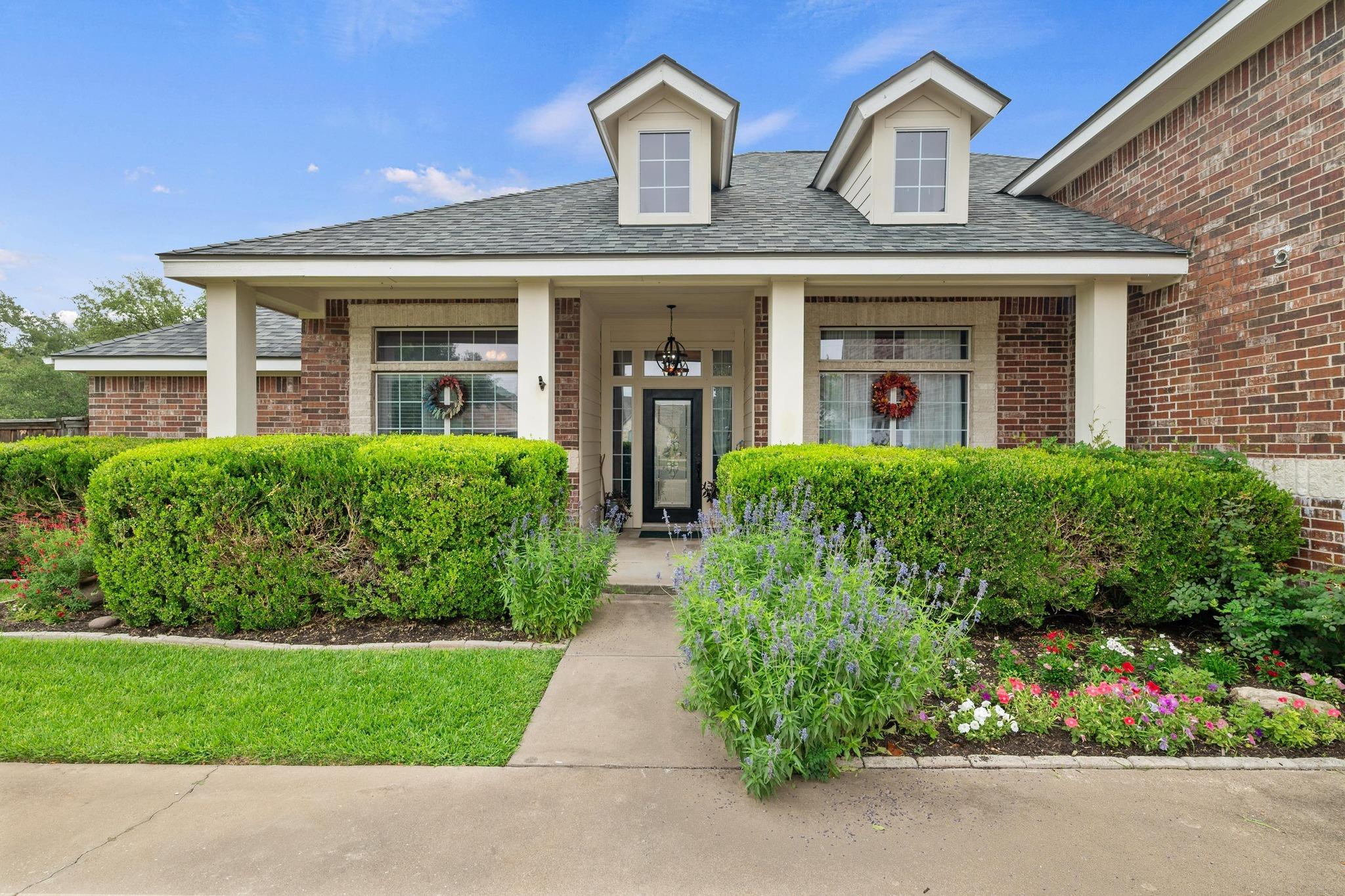 View of front of house with a shingled roof, a po